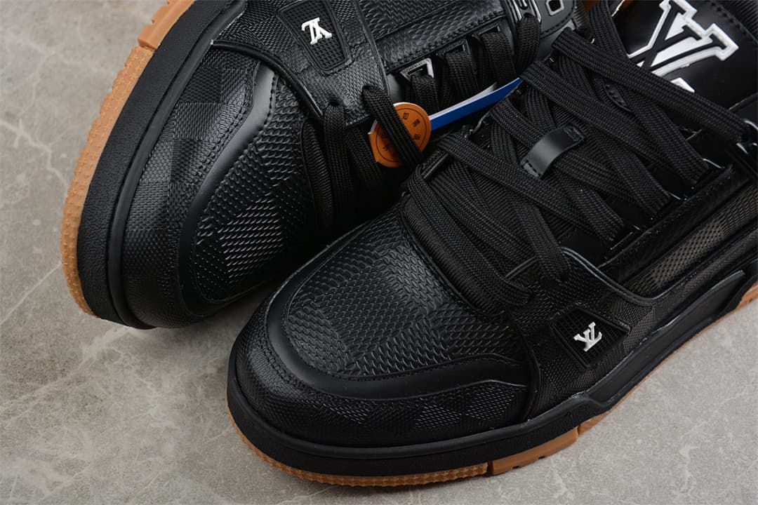 Close-up of the textured toe and lace-up areas of black sneakers
