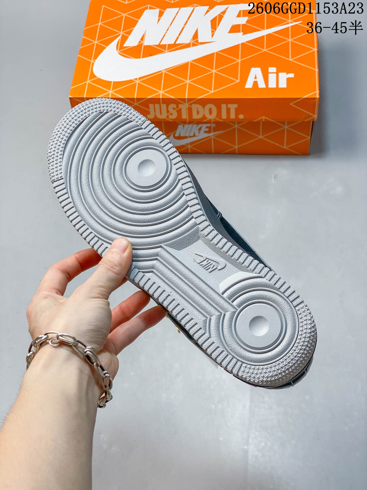 Close-up of the gray textured outsole and orange shoe box