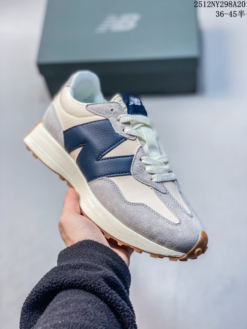 Angled view of the cream, gray and navy sneaker with its gum-colored outsole.