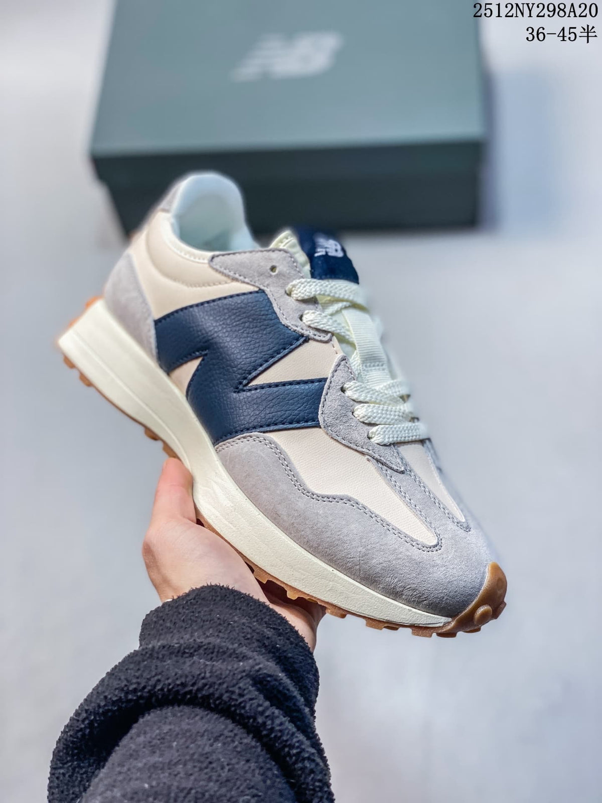 Angled view of the cream, gray and navy sneaker with its gum-colored outsole.