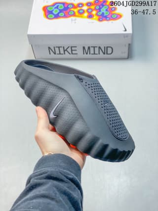 Side view of a dark gray Nike Mind slide showing the perforated upper panel and deeply segmented outsole.