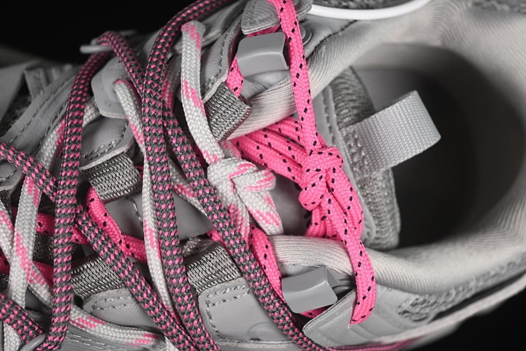 Close-up of the sneaker's contrasting pink, grey, and light-colored laces