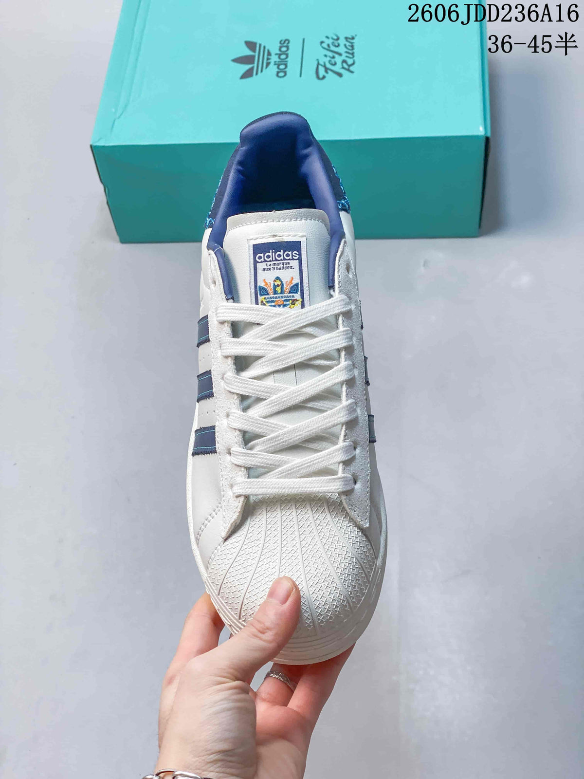 Top view of the Superstar shell toe, white laces, and blue-lined collar.
