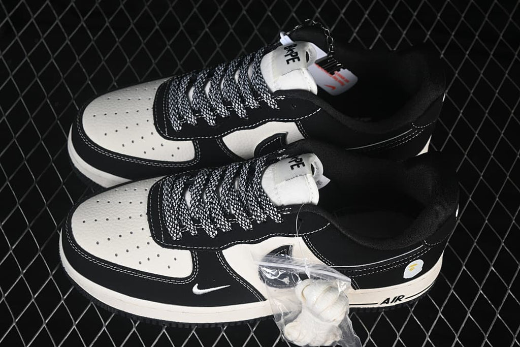 Pair of black and off-white low-top sneakers with patterned laces and an extra lace set.