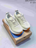 Pair of light-colored ASICS Gel-Kayano 33 running shoes with orange outsole accents on a shoebox