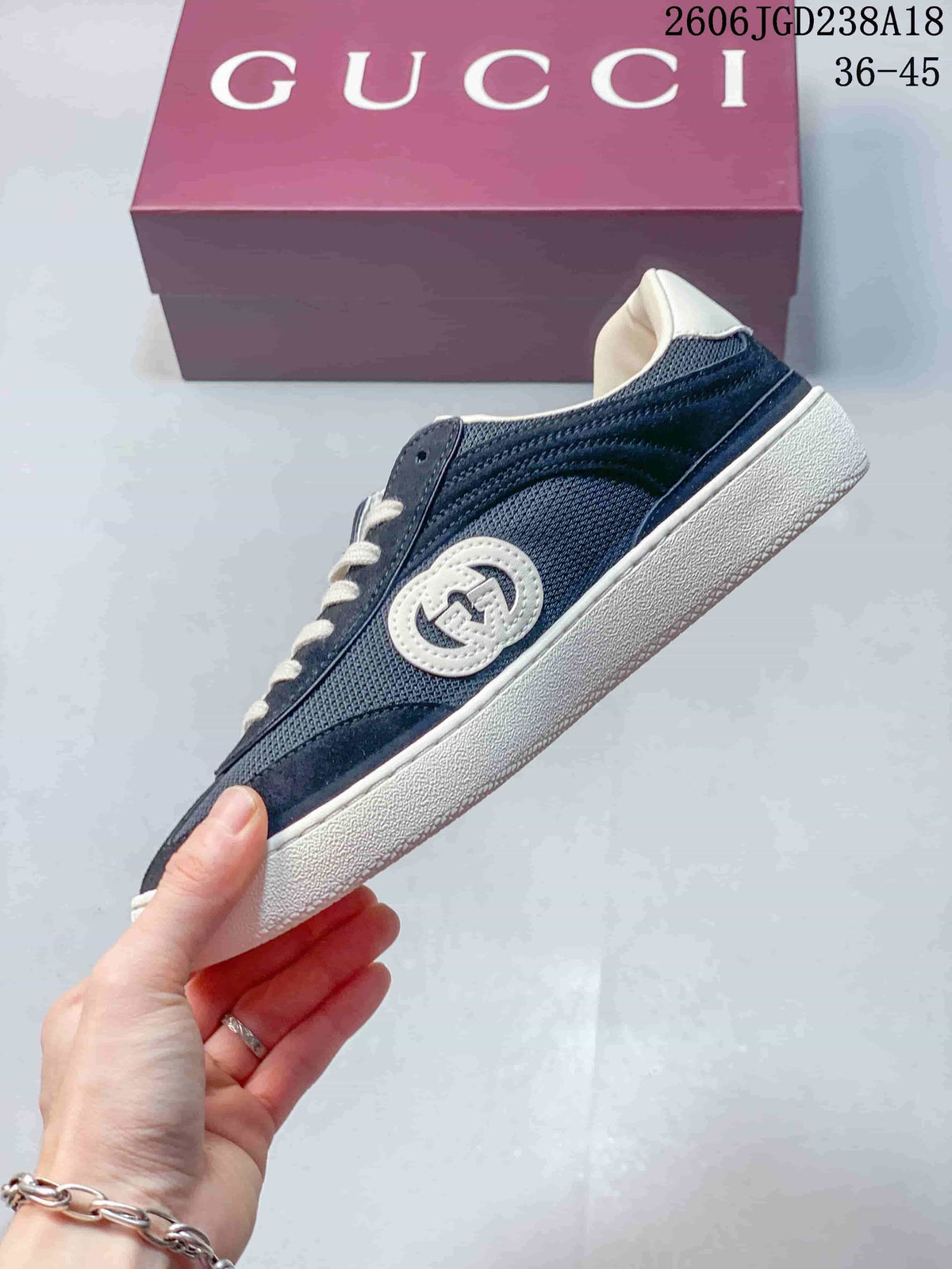 Side view of the navy low-top sneaker with circular emblem
