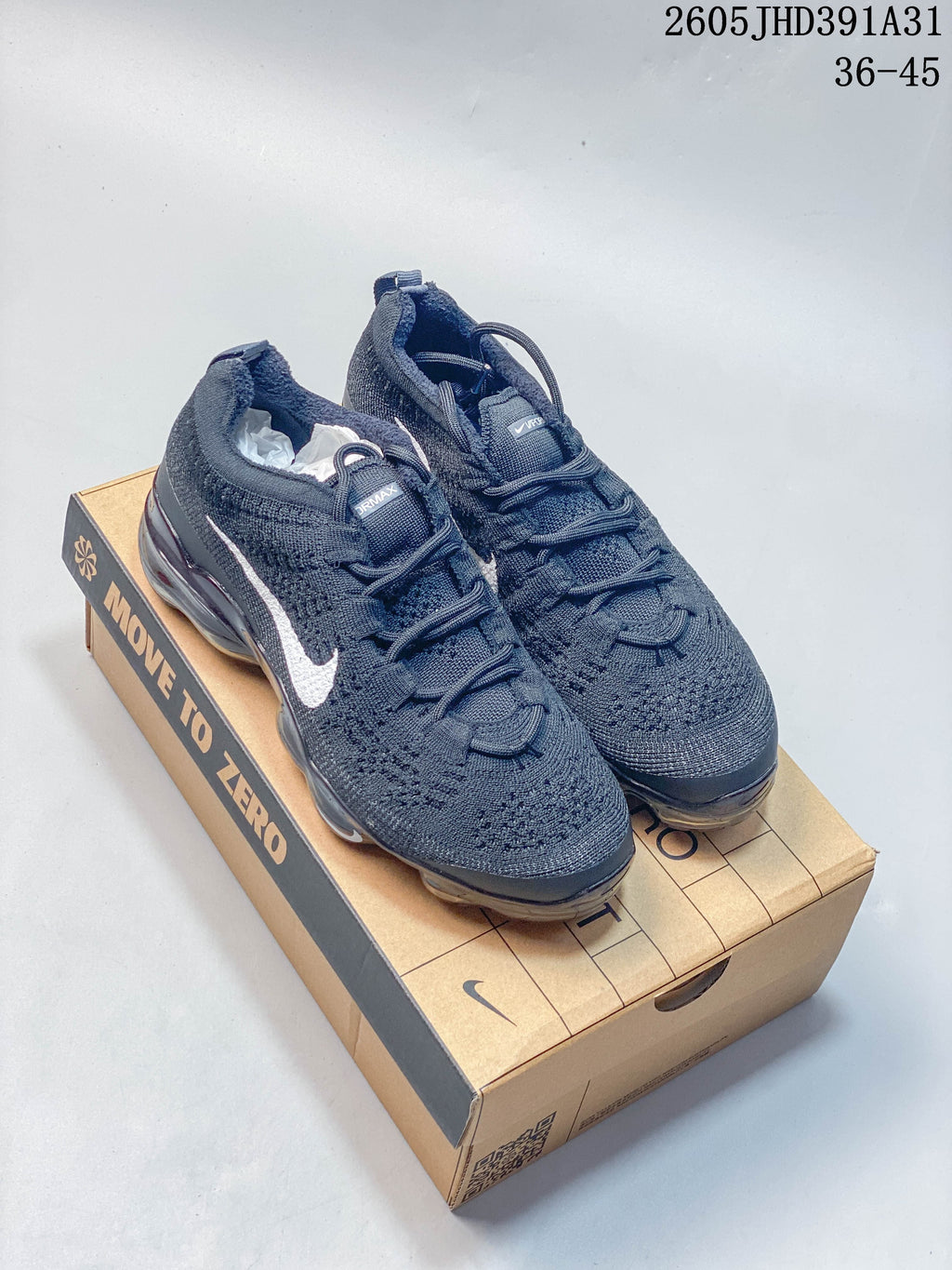 Pair of dark blue Nike Air VaporMax 2023 Flyknit shoes displayed on a Move to Zero box