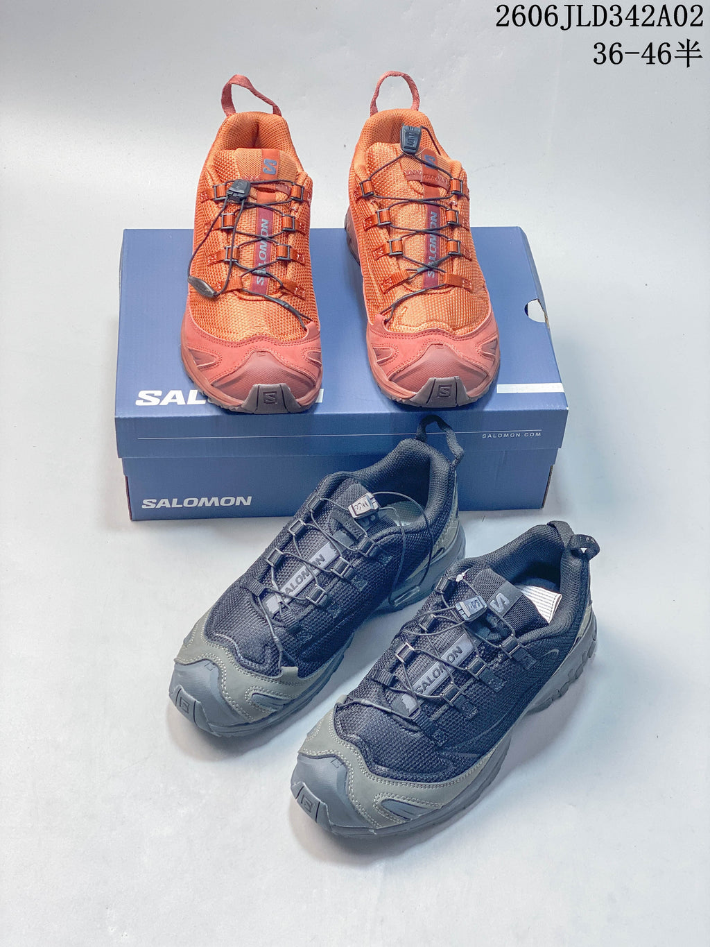 Pair of orange Salomon trail running shoes on a shoe box.
