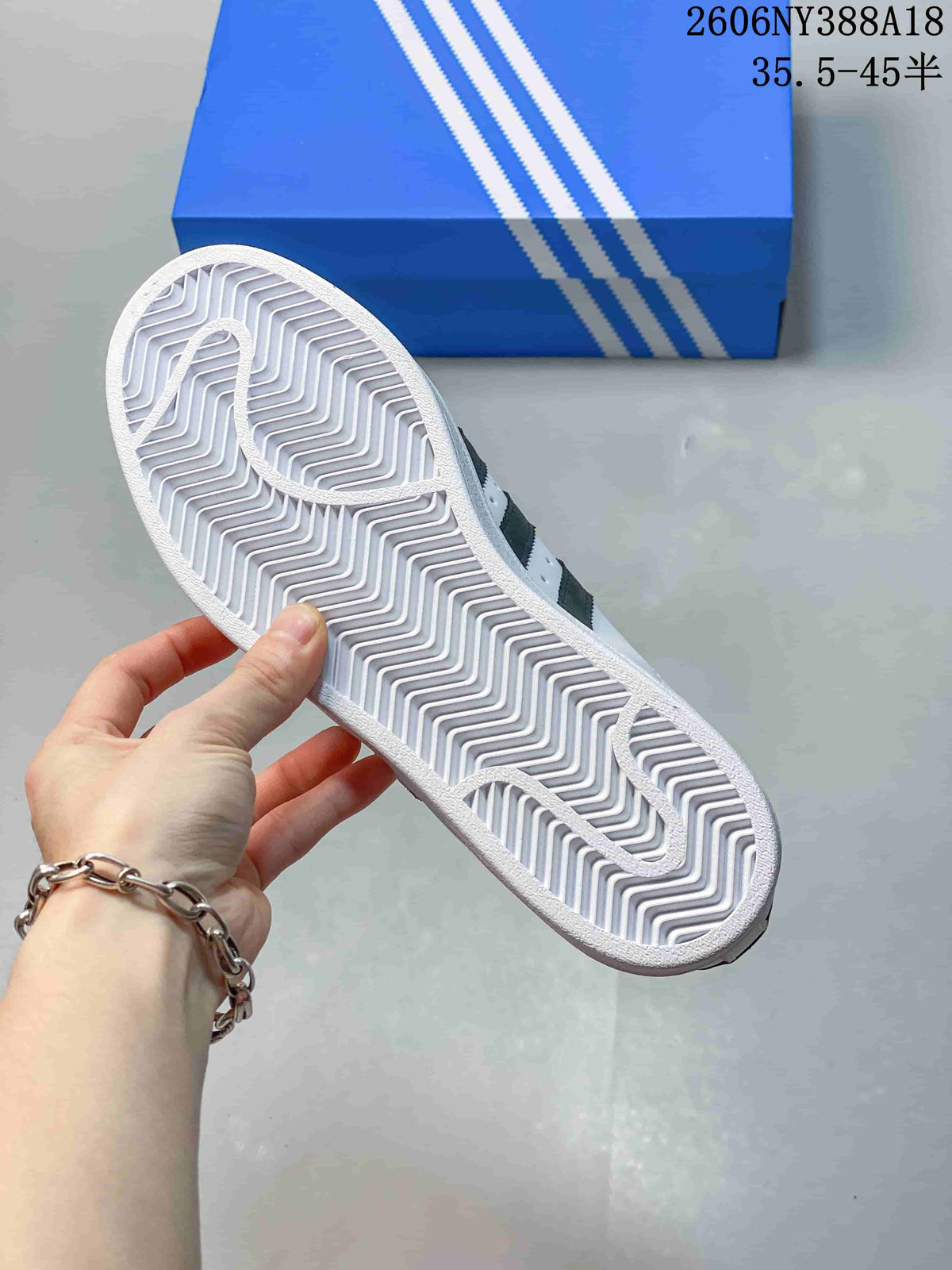 Underside view showing the patterned outsole of a white Superstar sneaker