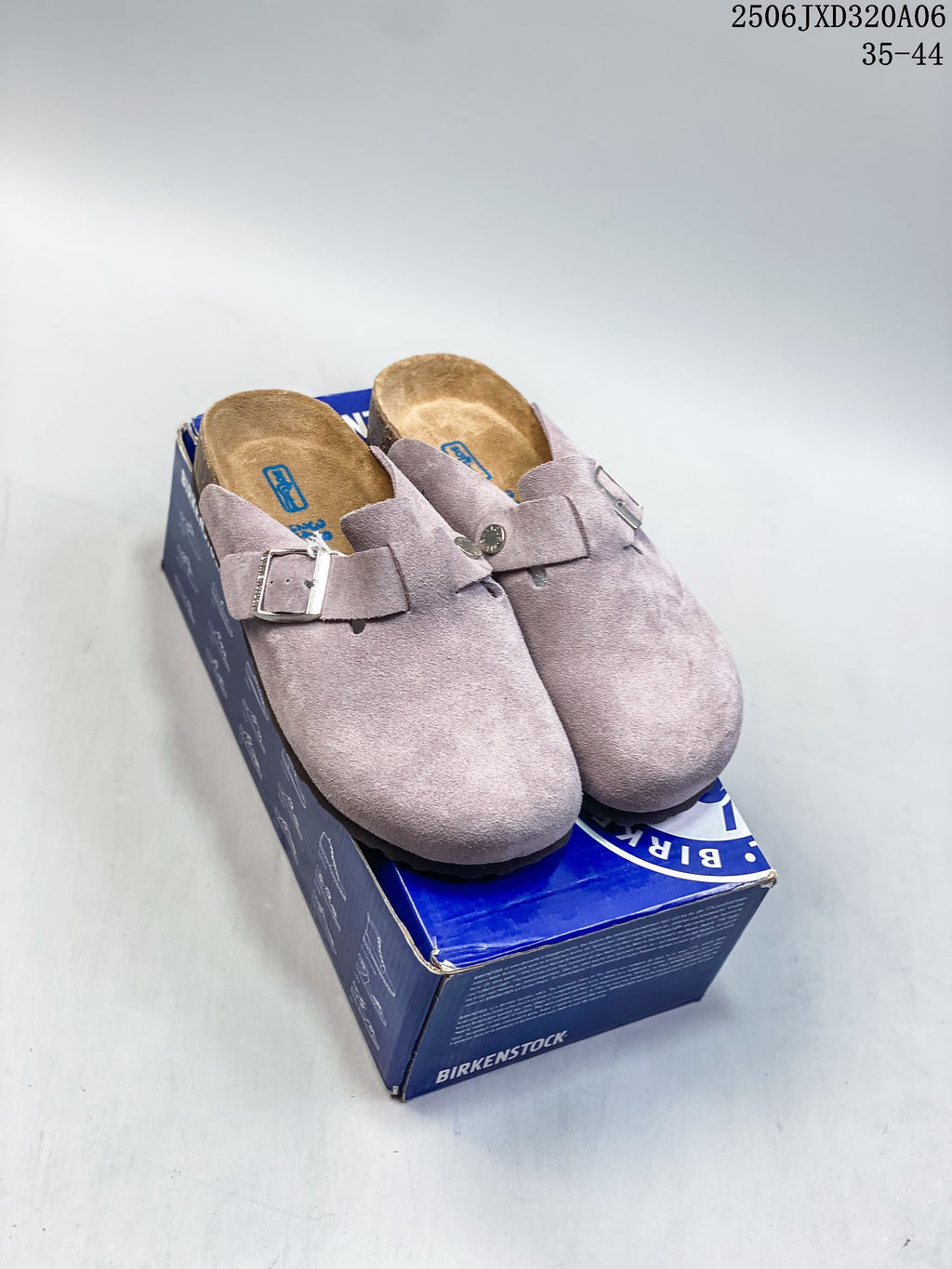 Pair of mauve-toned buckle clogs displayed on a blue shoebox
