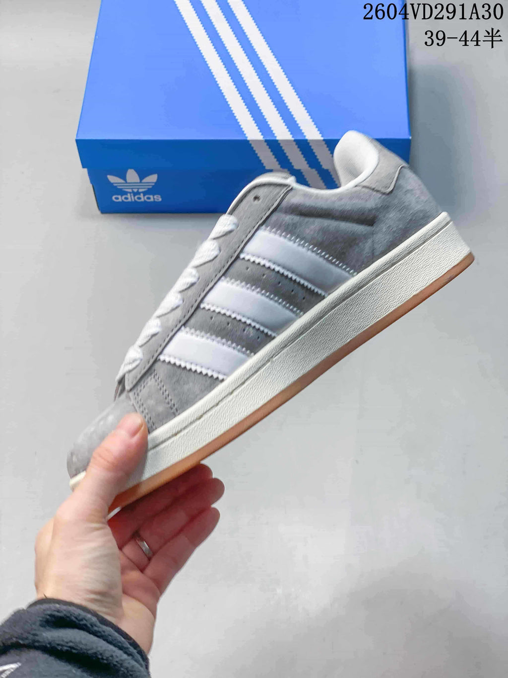 Side view showing grey upper, white stripes, and gum-colored outsole