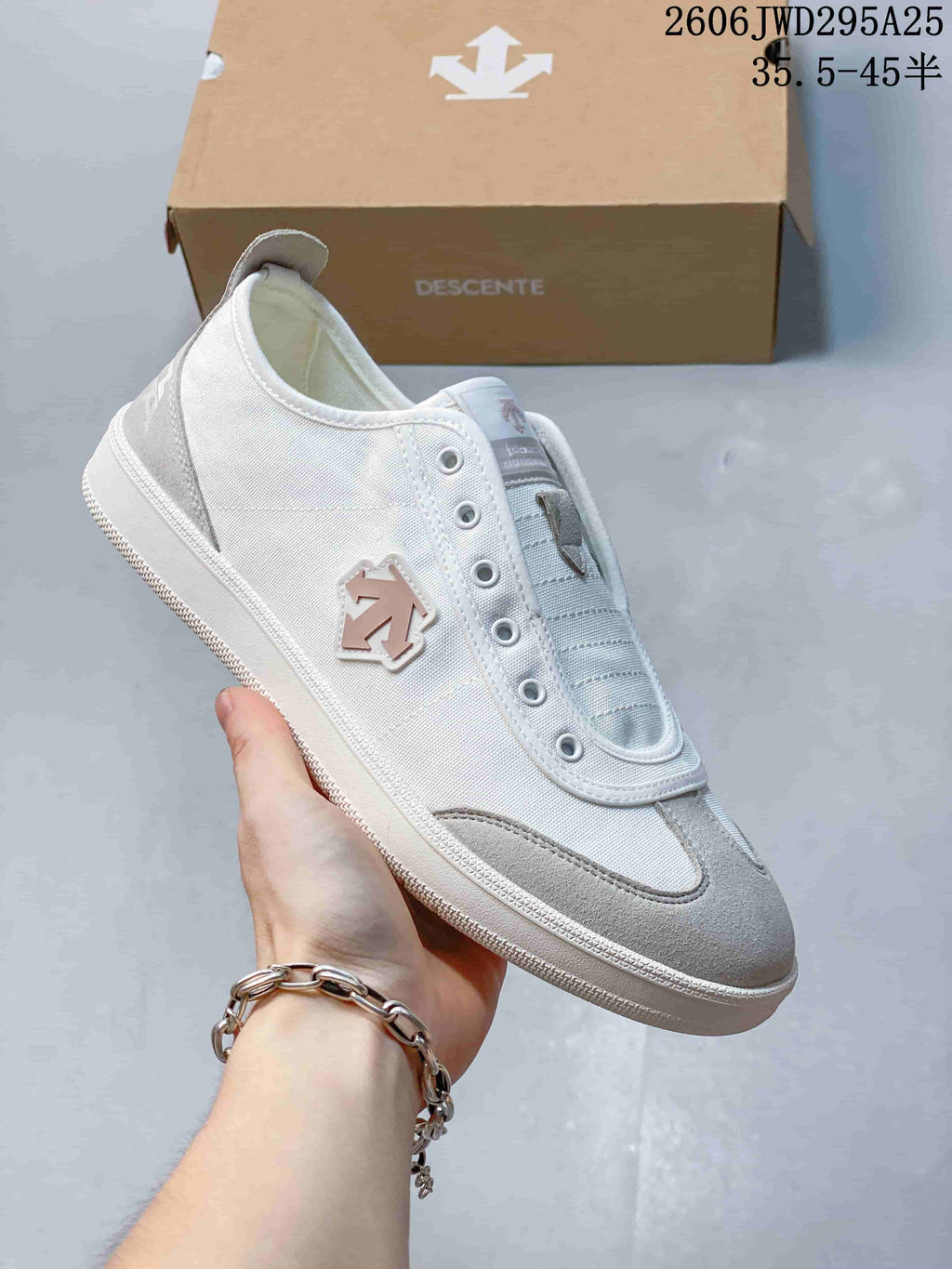 Side view of a white and gray DESCENTE CHRON sneaker with layered panels and metal eyelets
