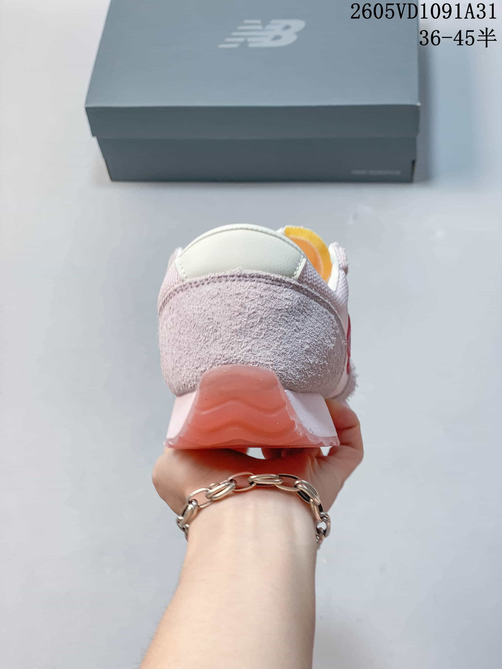 Rear view of a pale pink New Balance 471 sneaker showing the heel and outsole.