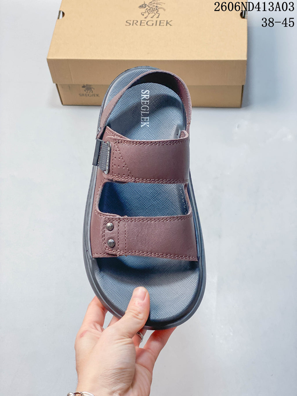 Top view of a brown sandal with two wide straps and a dark gray footbed.