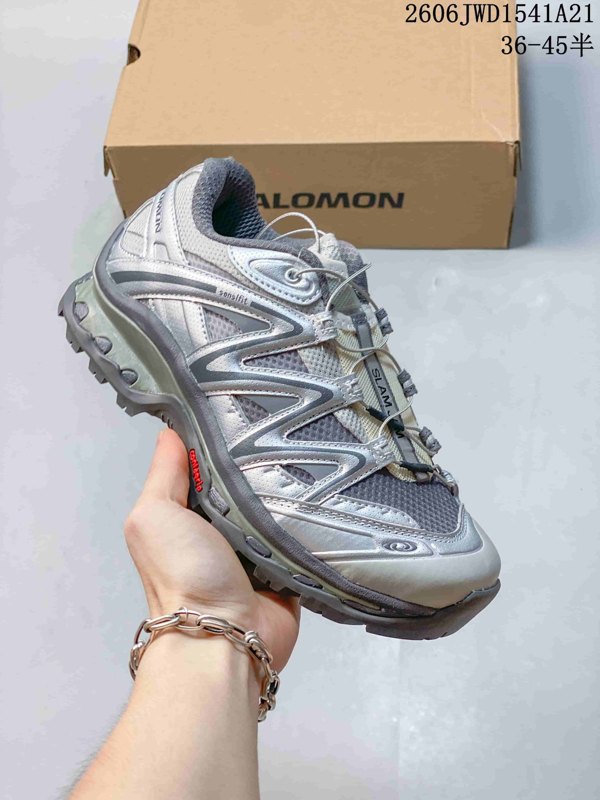 Angled side view of the silver and gray Salomon sneaker.