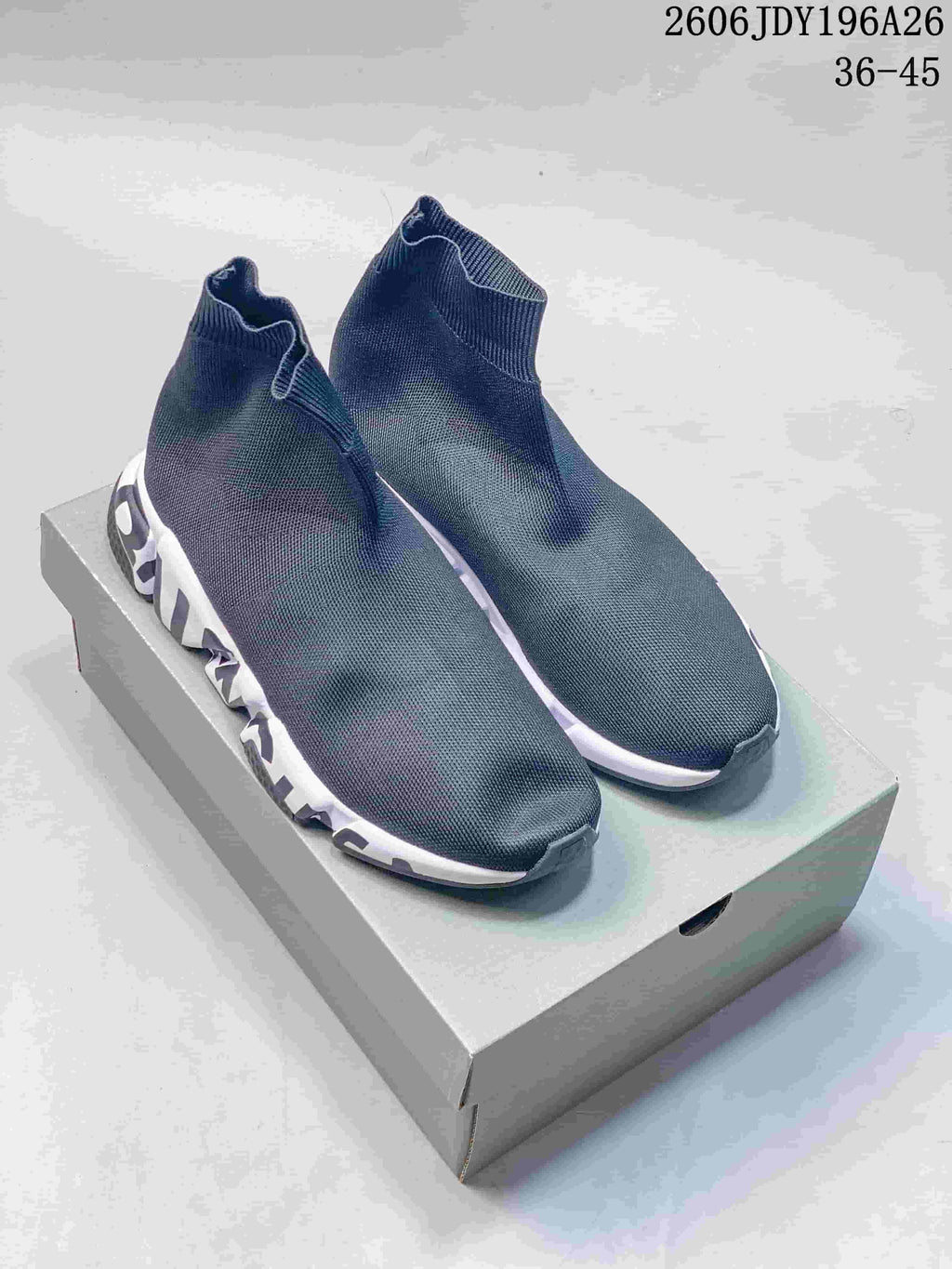 Pair of plain dark gray sock-style sneakers with white lettering on the sides of the soles.