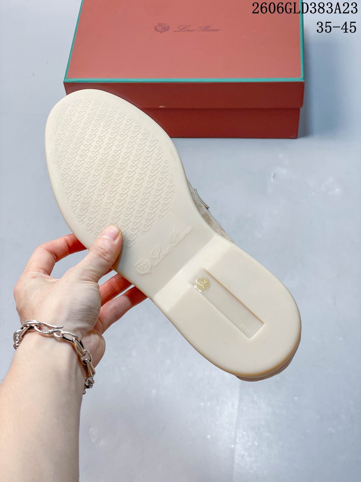 Underside of a light-colored loafer sole beside the shoe box