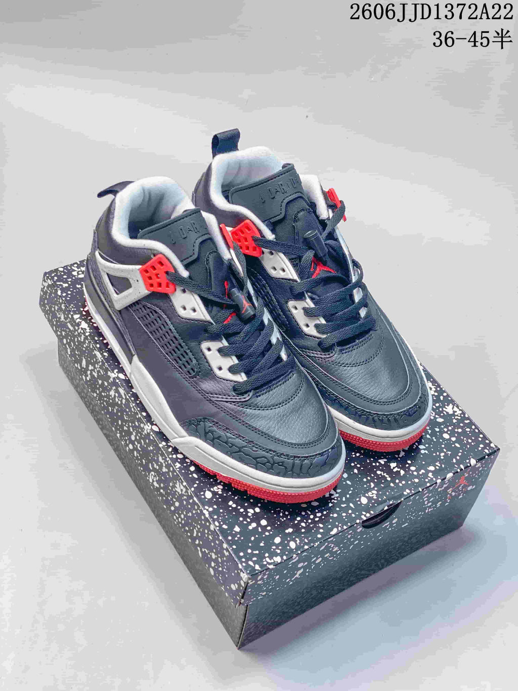 Pair of dark gray Jordan Spizike Low sneakers with white panels and red accents