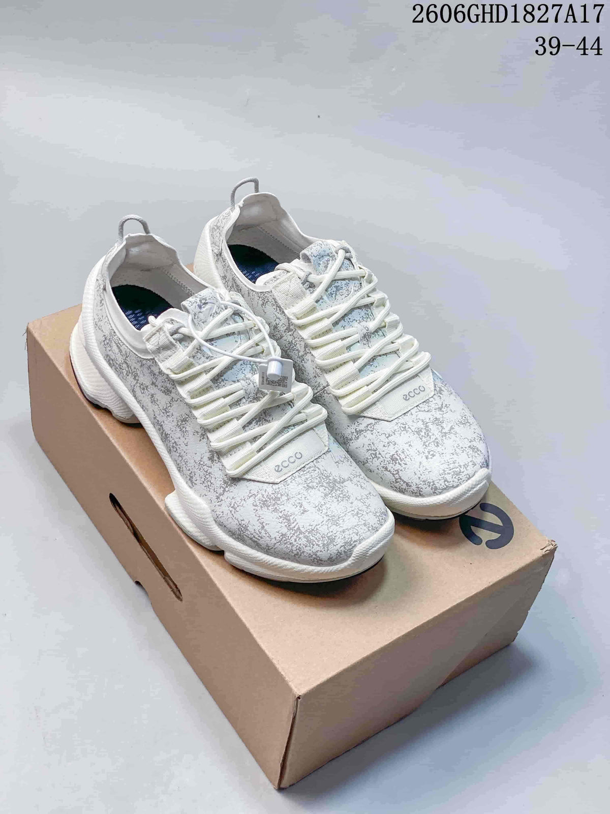 Pair of light-colored ECCO sneakers with a mottled gray pattern, shown on a shoe box.
