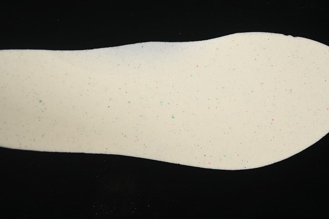 Light-colored shoe insert shown against a black background