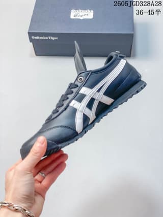 Side profile of a navy Onitsuka Tiger sneaker with white stripes and textured outsole