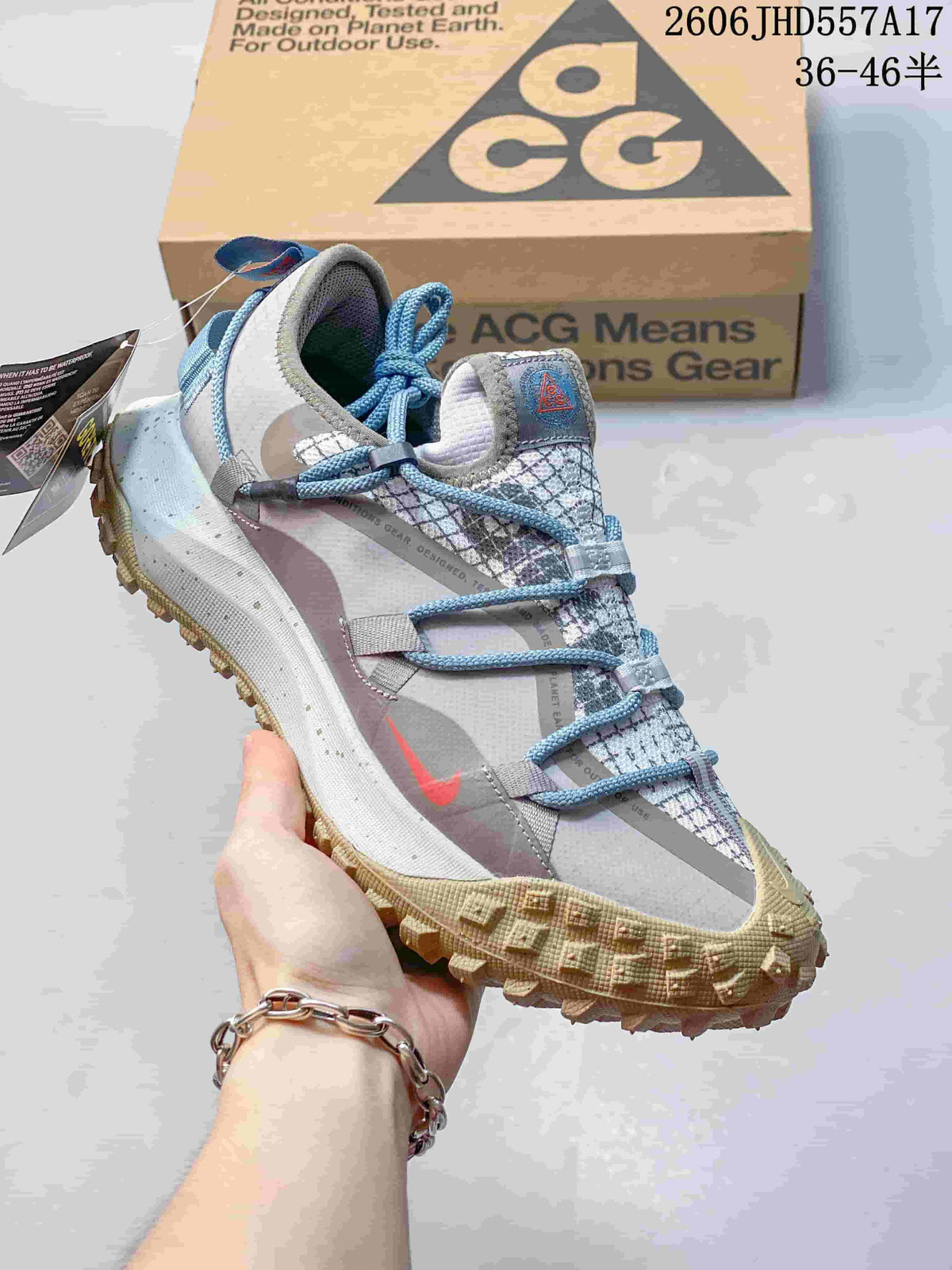 Nike ACG Mountain Fly sneaker in light gray with blue laces and a tan-toned outsole.