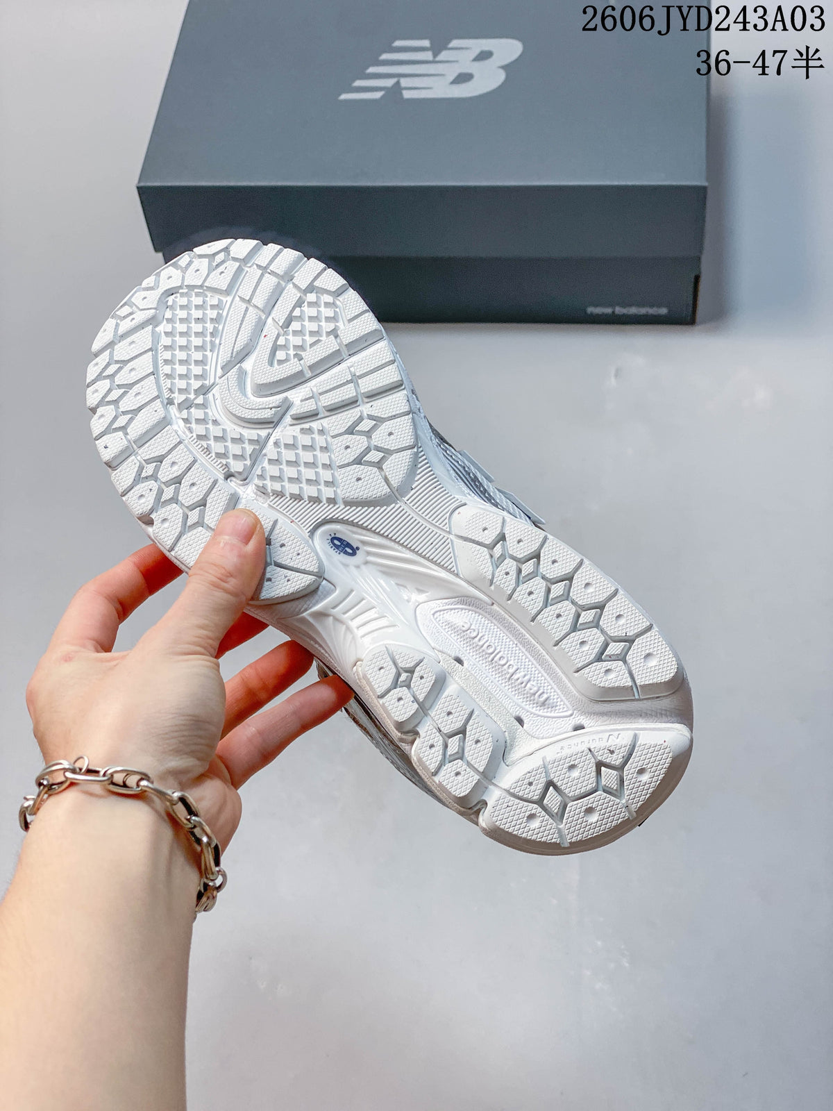 Close-up of the patterned outsole on a white and silver sneaker