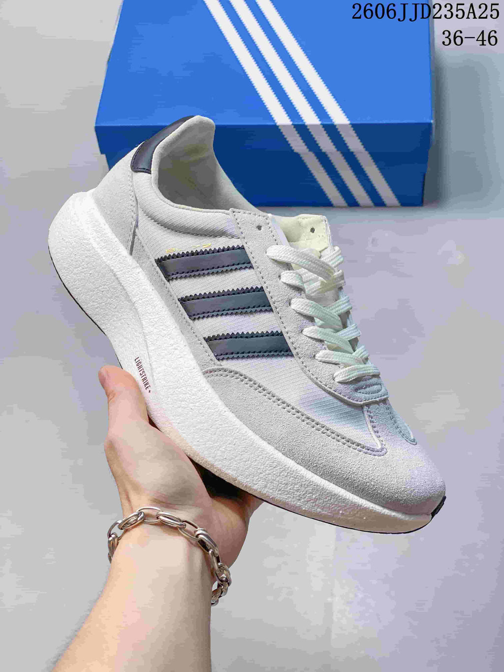 Side view of a light-colored Adidas Adizero SL 72 Pro sneaker with dark stripes