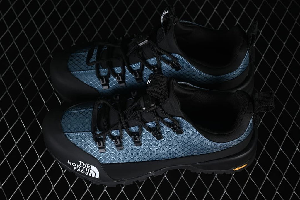 Pair of blue and black shoes shown from above and the side.