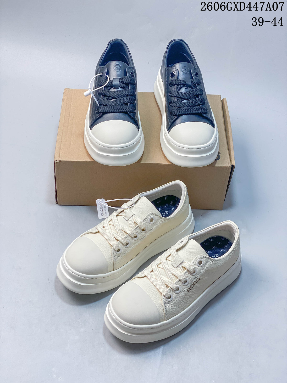 Navy ECCO lace-up sneakers with light toe panels, shown on a box.