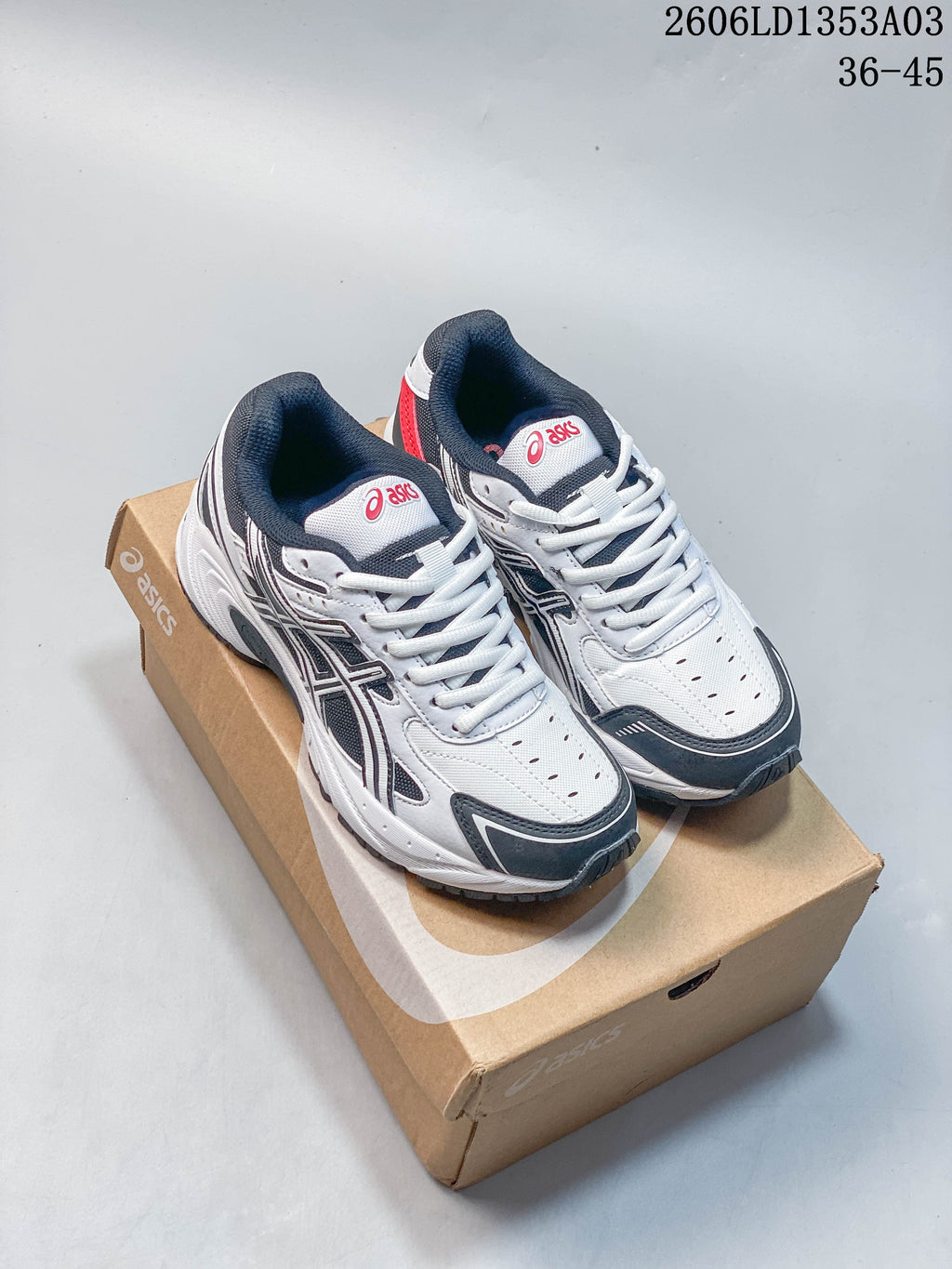 Pair of white, navy, and gray ASICS GEL-170TR sneakers with red accents, shown on a shoebox.