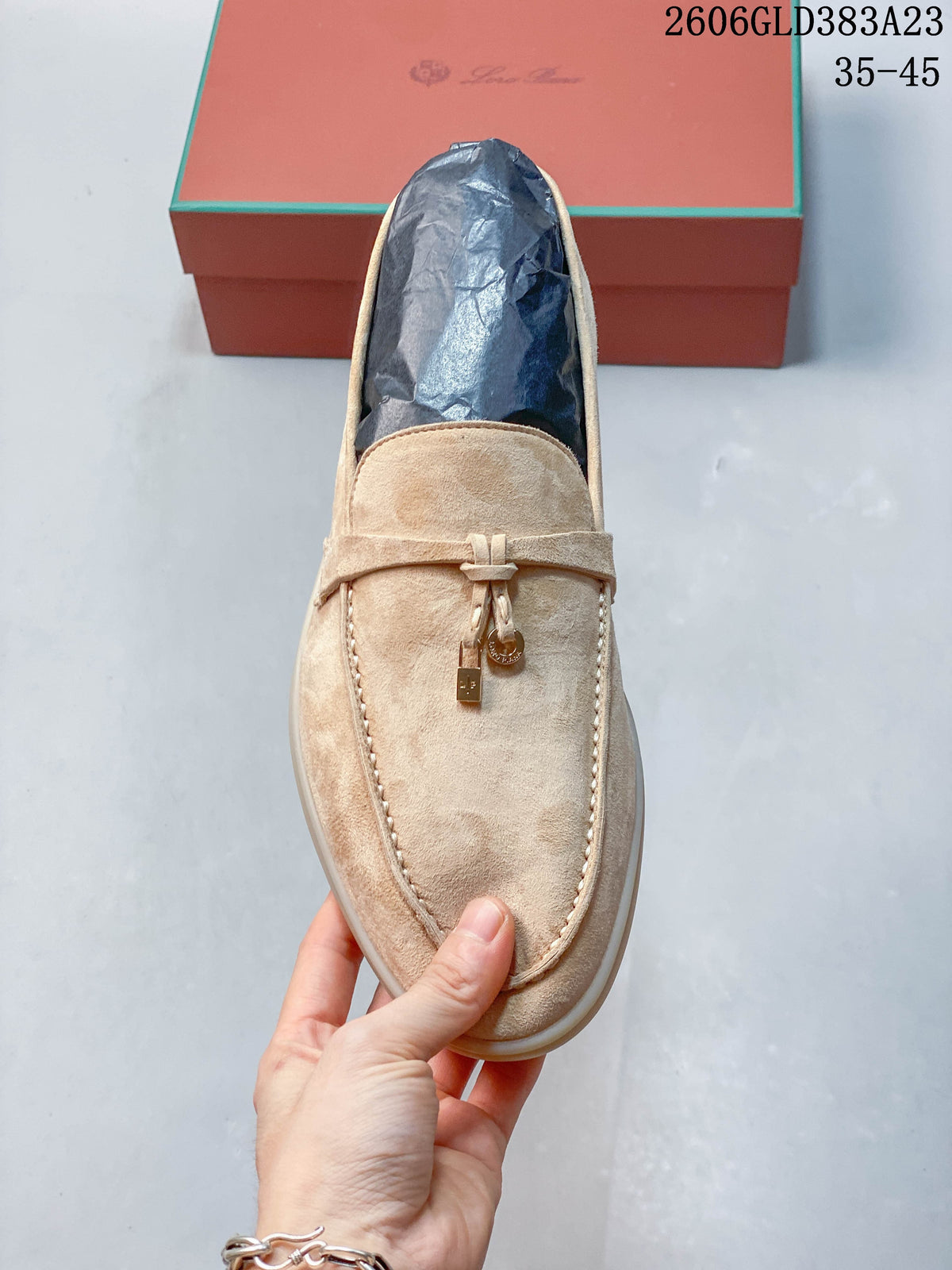 Top view of a beige loafer showing the moc-toe seam and strap detail