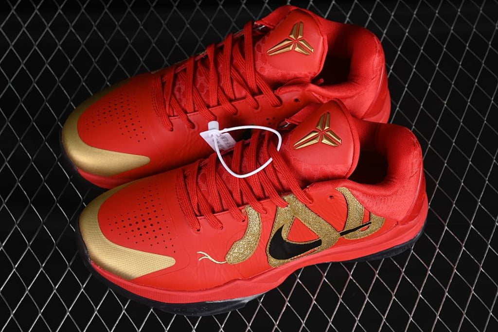 Pair of red and gold low-top basketball shoes shown from above