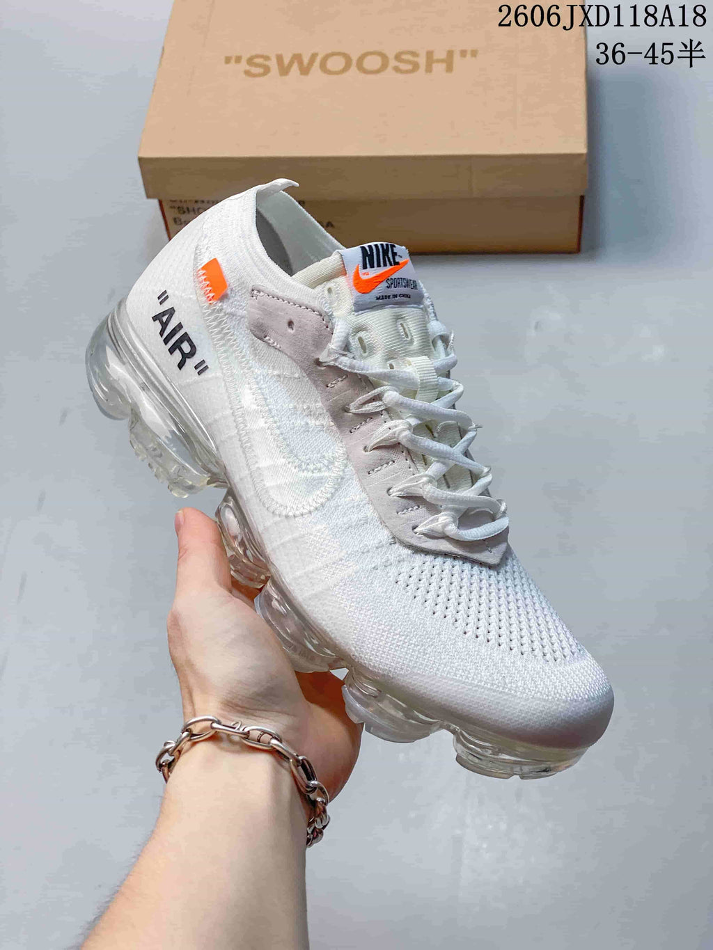 White low-top sneaker shown from the side with orange accents and a segmented sole.
