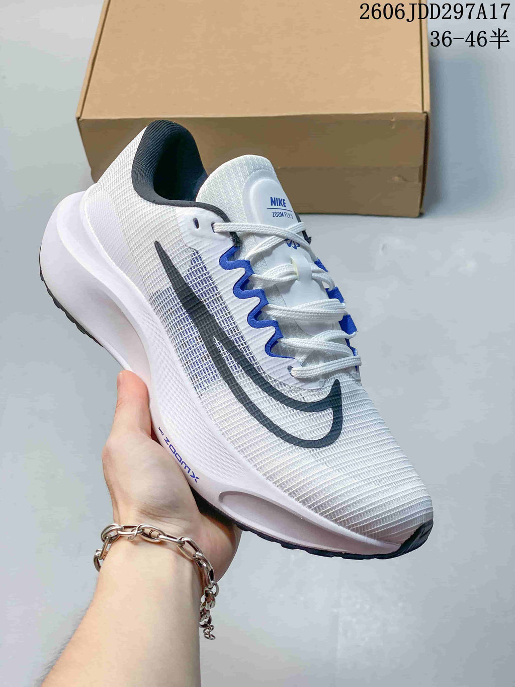Angled close-up of the white Nike Zoom Fly 5 running shoe with blue and dark gray accents.