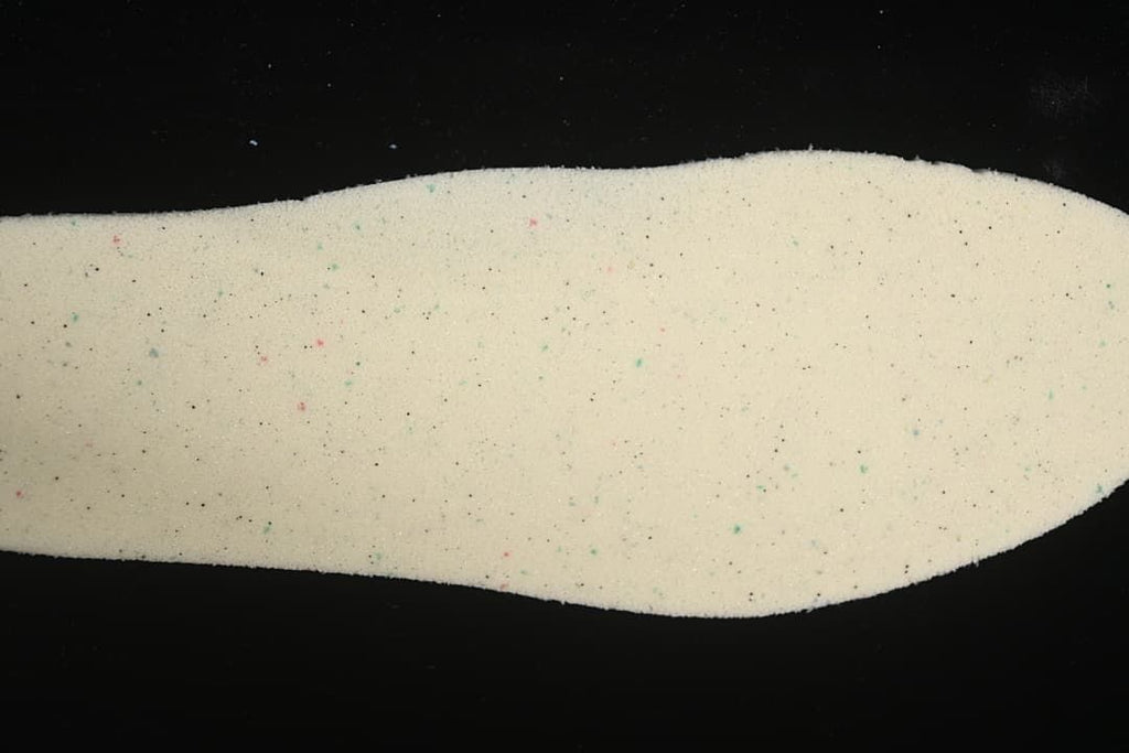 Close-up of a light-colored shoe insert with small multicolor flecks