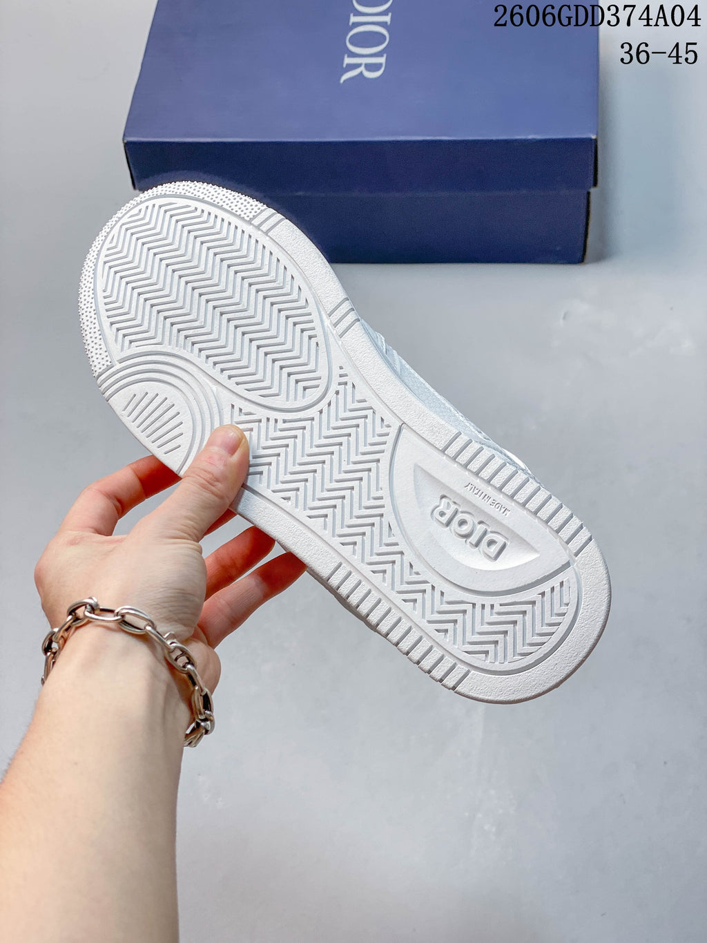 Underside of a white sneaker with a patterned tread