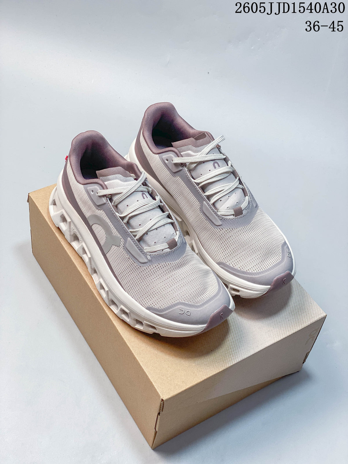 Pair of pale gray and white On Cloudmonster 2 running shoes with muted mauve and gray accents.