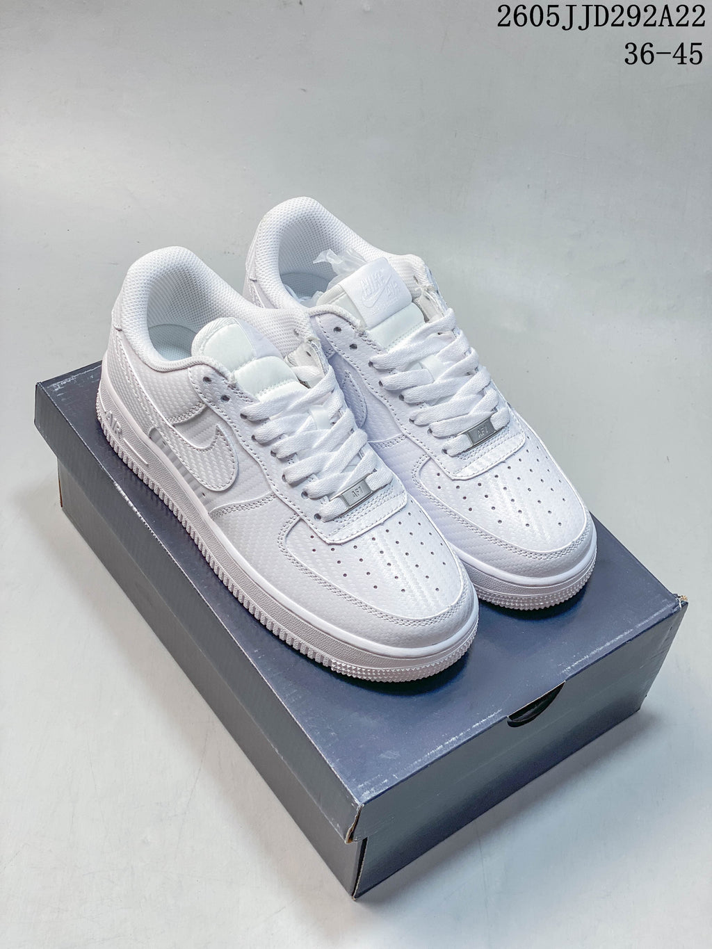 Pair of white Nike low-top sneakers displayed on a shoebox
