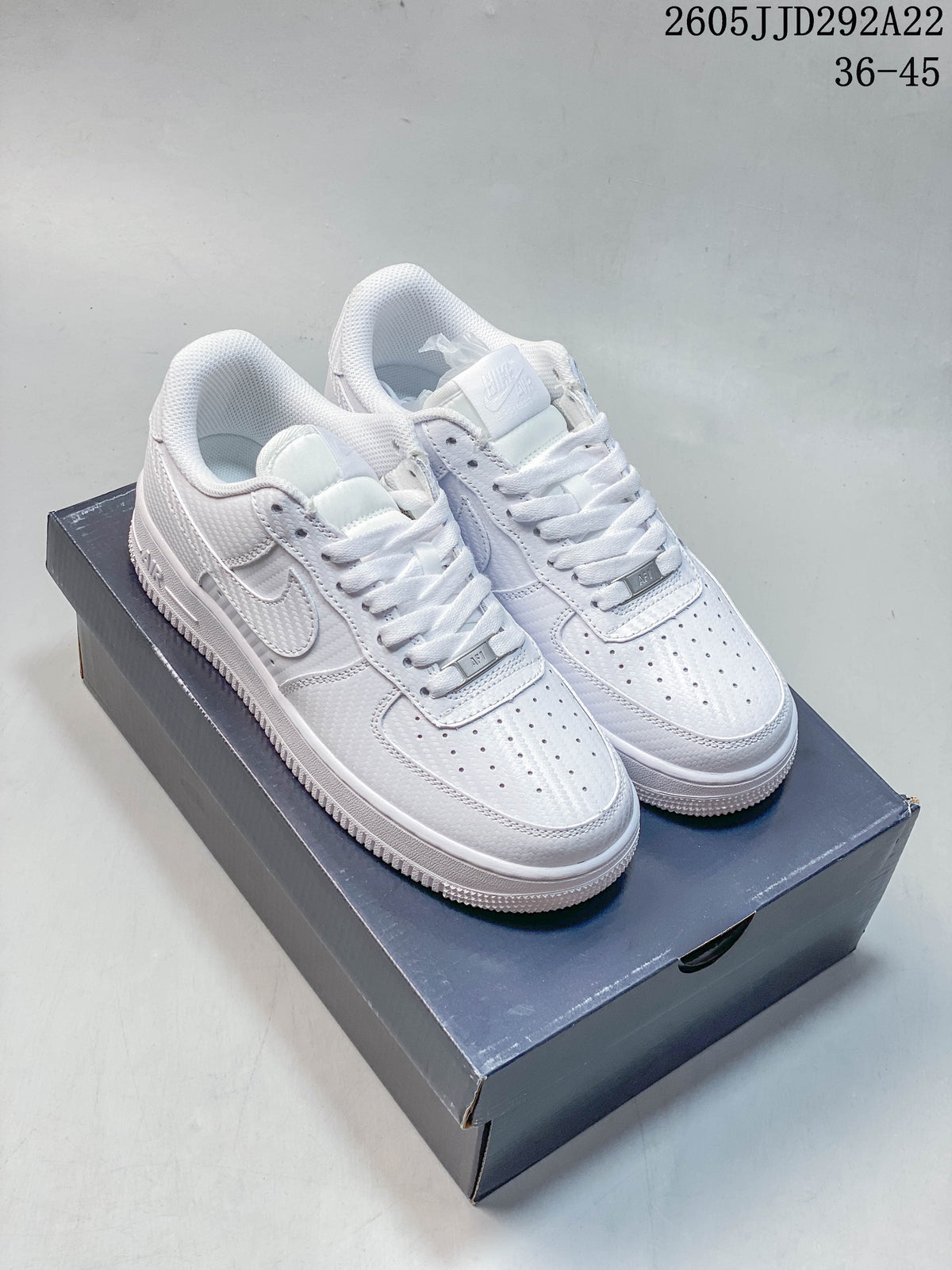 Pair of white Nike low-top sneakers displayed on a shoebox