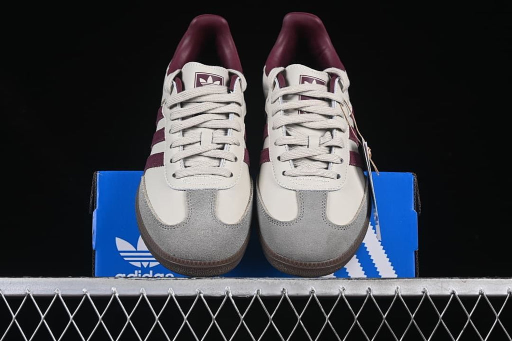Front view of the pair showing gray toe overlays, cream uppers, and burgundy accents.