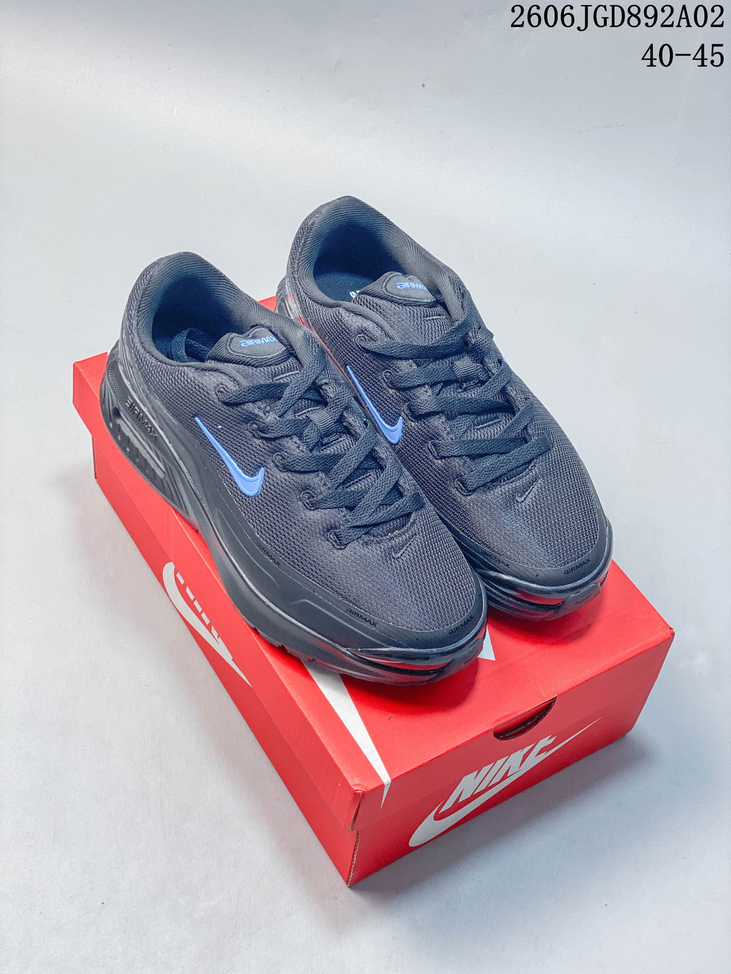 Pair of dark gray Nike Air Max BIA shoes with blue accents on a red shoebox