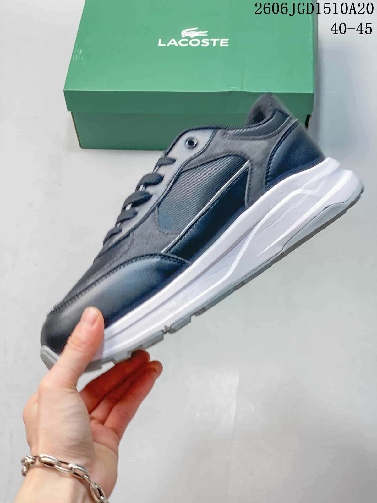 Side profile of a grey and navy Lacoste sneaker with a white midsole.