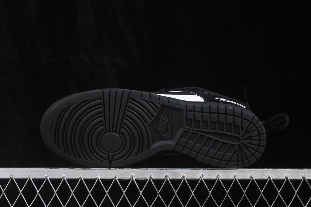 Underside view of a black sneaker showing the circular traction pattern and Nike-branded outsole.