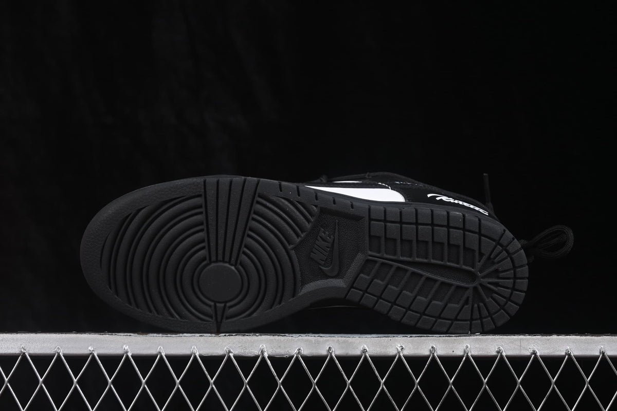 Underside view of a black sneaker showing the circular traction pattern and Nike-branded outsole.