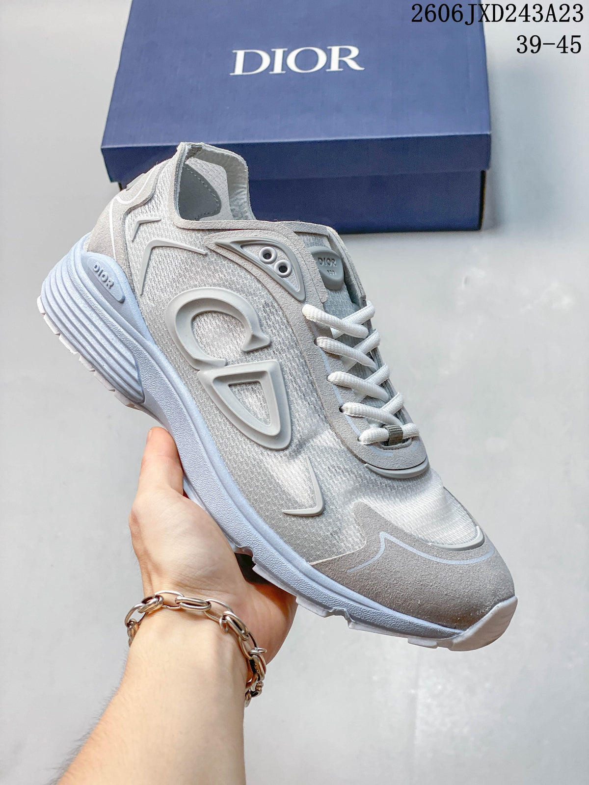 Gray and white low-top sneaker with pale blue-gray sole and details.