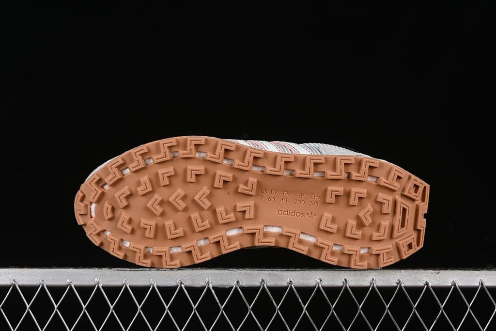 Underside of the sneaker with a patterned gum-colored outsole and size markings