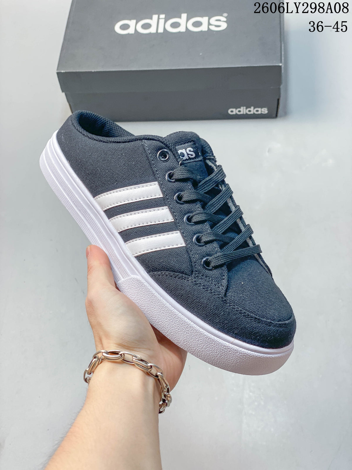 Close-up of a navy adidas mule sneaker with white side stripes and a lace-up front.