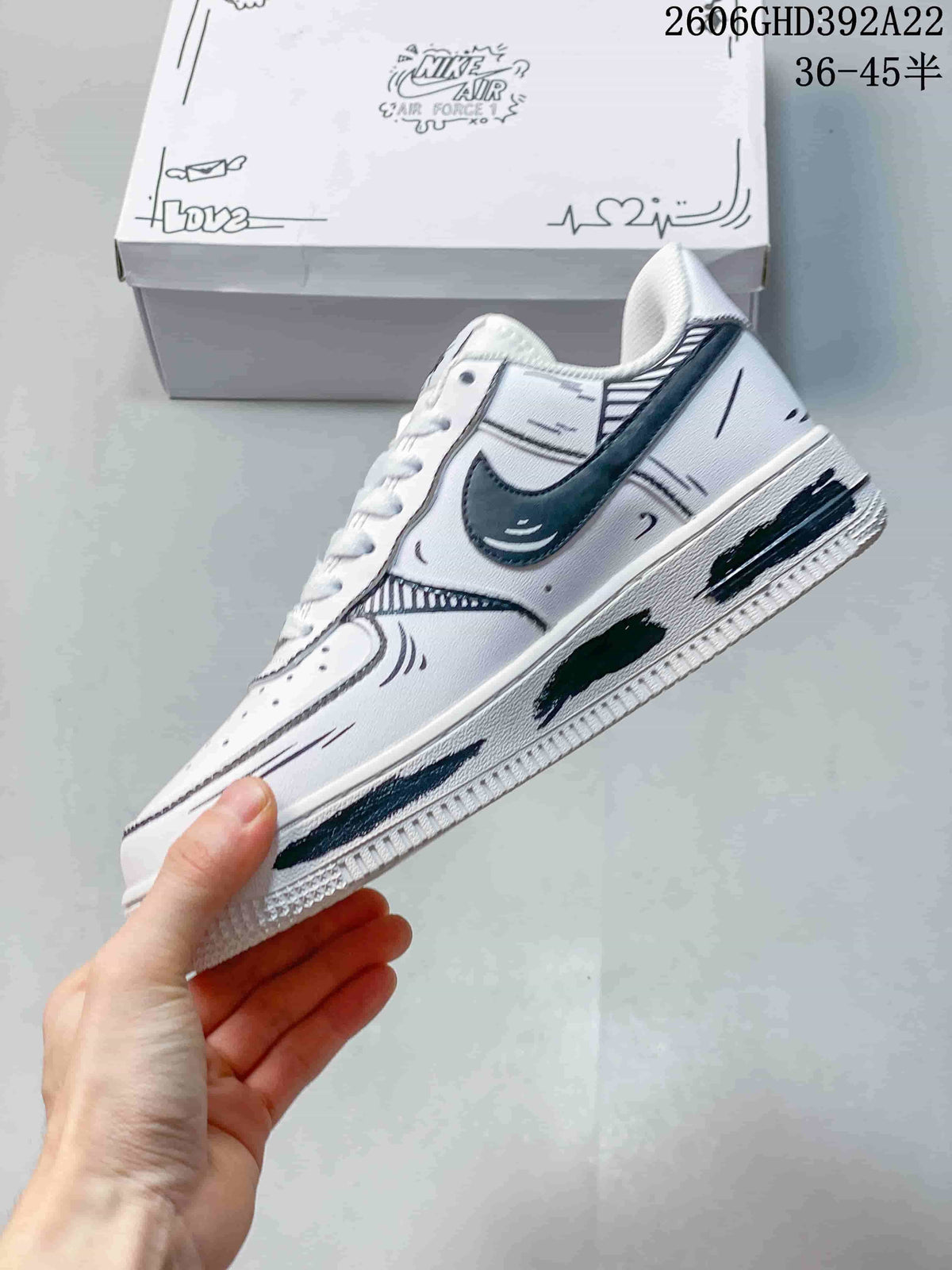 Side view of the white low-top sneaker with a dark swoosh and black graphic detailing.
