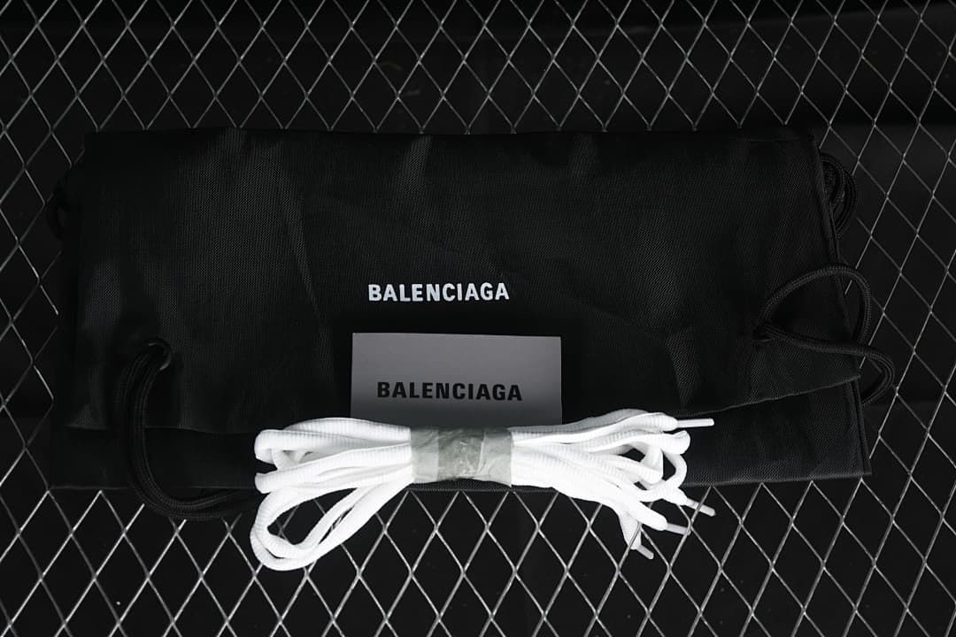 Black drawstring bag and spare white laces shown with the sneakers